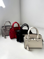 Borsa a mano mini in pelle martellata, elegante e versatile. Design ispirato ai modelli iconici, con chiusura metallica raffinata e dettagli curati. Perfetta per outfit casual chic o look sofisticati. Disponibile in colori neutri e classici, ideale per ogni occasione. Scopri la nuova collezione di borse di lusso dal design esclusivo. Modello Hermès Kelly 