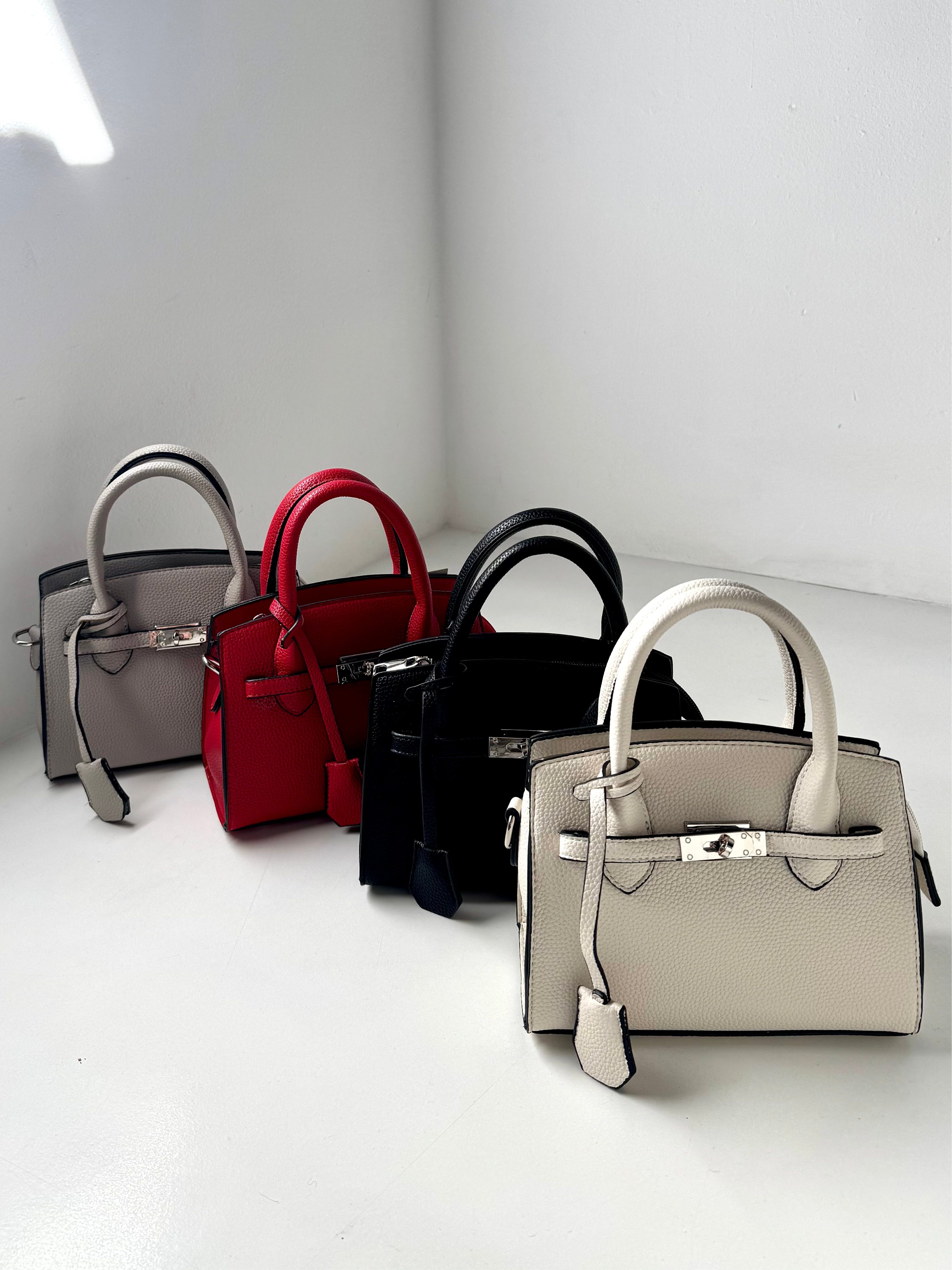 Borsa a mano mini in pelle martellata, elegante e versatile. Design ispirato ai modelli iconici, con chiusura metallica raffinata e dettagli curati. Perfetta per outfit casual chic o look sofisticati. Disponibile in colori neutri e classici, ideale per ogni occasione. Scopri la nuova collezione di borse di lusso dal design esclusivo. Modello Hermès Kelly 